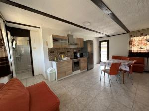 a kitchen and living room with a table and a couch at Avar Apartman in Igricetanya +35 photos