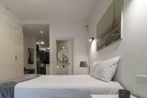 a white bedroom with a bed and a mirror at Apartamento Bronce by Clabao in Madrid +11 photos