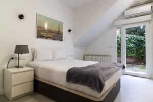 ein weißes Schlafzimmer mit einem großen Bett und einem Fenster in der Unterkunft Apartamento Bronce by Clabao in Madrid + 11 Fotos