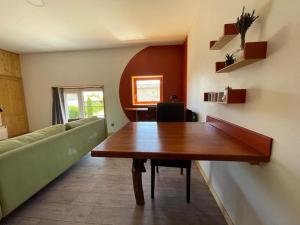 un soggiorno con un tavolo di legno e un divano di Appartement neuf au coeur du vignoble dans village tous commerces a Cahuzac-sur-Vère