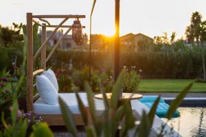 a garden with a bed and a table and the sunset at Private Pool Villa by the Sea in Kalamata +37 photos