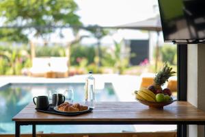 a table with a plate of fruit and a bottle of water at Private Pool Villa by the Sea in Kalamata