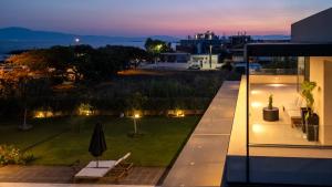 a balcony of a house with a garden at night at Private Pool Villa by the Sea in Kalamata