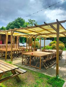 a wooden pavilion with wooden tables and benches at Cascina Bellaria in Milan