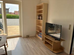 a living room with a television and a book shelf at Kalundborg centrum in Kalundborg