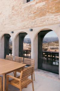 an outdoor patio with wooden tables and chairs at Fam de Vida in Gratallops