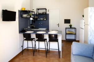 a kitchen with a counter with four chairs around it at Peschici Central Room - vista mare in Peschici