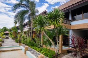 un complexe avec des palmiers devant un bâtiment dans l'établissement BaanRimNam Resort Trat, à Trat