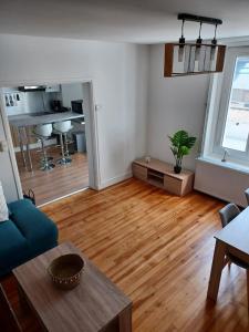 a living room with a blue couch and a wooden floor at Gite du Bois Rosé in Fécamp