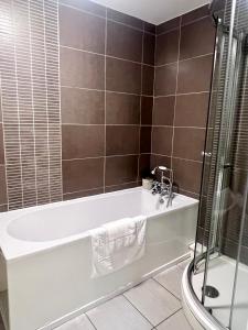 a bathroom with a bath tub and a shower at Ropewalks City Centre Apartment with Roof Terrace in Liverpool +14 photos