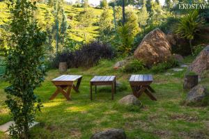 two picnic tables in a garden with rocks at EKOSTAY - Winterfell Chalet Villa in Coonoor +25 photos