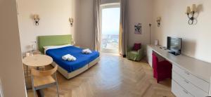 a bedroom with a bed and a table and a television at Residence gli Angioini srl in Naples