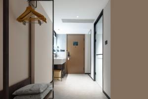 a hallway with a door and a sink in a room at Atour Hotel Changzhou Universal Dinosaur City Media Centre in Changzhou