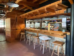 a bar in a restaurant with stools at Areál Kamínka - POKOJE A APARTMÁNY in Roštín