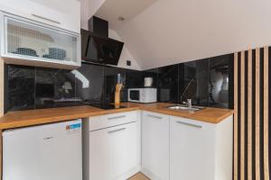 een keuken met witte kasten en een magnetron bij APARTAMENT nr 5 in Kąty Rybackie