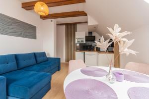 een woonkamer met een blauwe bank en een tafel bij APARTAMENT nr 5 in Kąty Rybackie