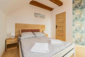 een slaapkamer met een bed met twee handdoeken erop bij APARTAMENT nr 5 in Kąty Rybackie