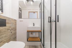 een badkamer met een wastafel en een douche bij APARTAMENT nr 5 in Kąty Rybackie