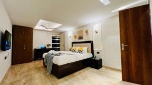 a bedroom with a bed and a television in it at ZEN Suites Gurgaon - LUXE Stays Collection in Gurgaon