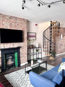 a living room with a brick fireplace and a tv at Ropewalks City Centre Apartment with Roof Terrace in Liverpool