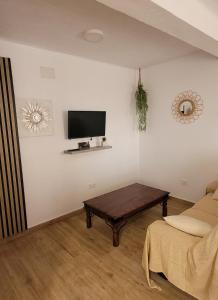 a living room with a tv and a coffee table at Casa La Retama in La Barca de la Florida