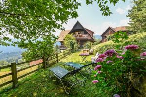 una casa su una collina con sedie e fiori di Jagawirt Bauernhaus a Grubberg