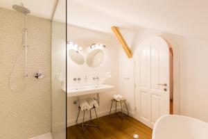 baño blanco con ducha y lavamanos en Raffl's Sweet Little Home, en Sankt Anton am Arlberg