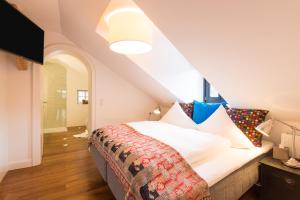 Schlafzimmer mit einem Bett mit weißer Bettwäsche und Kissen in der Unterkunft Raffl's Sweet Little Home in Sankt Anton am Arlberg