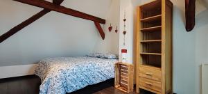 een slaapkamer met een bed en een boekenplank bij La Grenouille - Centre Ville - Proche Parking Gratuit - Commerces à Proximité in Sélestat