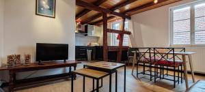 een woonkamer met een televisie en een tafel en stoelen bij La Grenouille - Centre Ville - Proche Parking Gratuit - Commerces à Proximité in Sélestat
