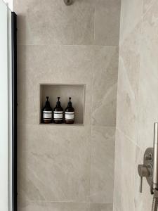 three bottles on a shelf in a bathroom at Da Lydia in Treviso +11 photos