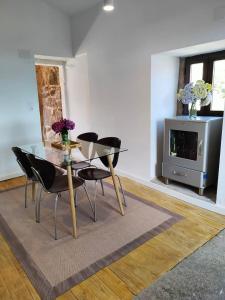 a dining room with a glass table and chairs at Casa Rural Xures Lobios in Pereira