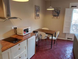 a kitchen with a table with chairs and a microwave at El Palacito de Arnedillo in Arnedillo