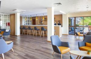 a waiting area in a hospital with chairs and tables at Hotel D. Luis in Coimbra