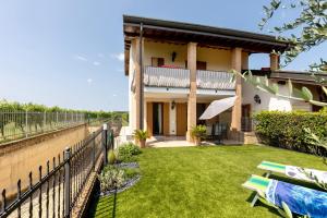 une maison avec une clôture et une cour gazonnée dans l'établissement Katy Lake Lavanda, à Peschiera del Garda