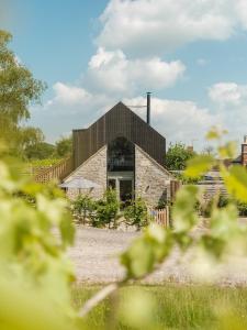 a stone building with a black roof at The Old Winery Cottage No1 in Shepton Mallet