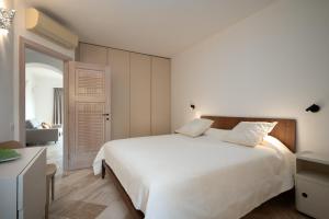 een slaapkamer met een wit bed en een bank bij Sherden suites - Your House in Sardinia in Golfo Aranci +61 foto's