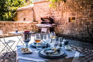 a table with glasses and plates of food and wine at Les Hauts de Sauliès - Chambre et Table d'Hôtes de charme in Vers