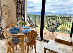 a dining room with a table and a balcony at Domek Tatry - Stacja Wierchowa 972 m in Brzegi