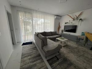 a living room with a couch and a tv at Rent Apartament Lalzy Bay in Draç