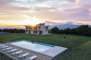 a house with a swimming pool and lounge chairs at Naubari Winery in Saguramo