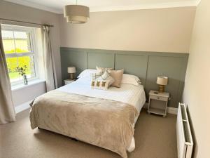 a bedroom with a large bed and a window at Kionslieu Farm Cottages in Foxdale +90 photos