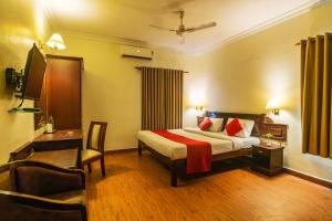 a hotel room with a bed and a chair at Hotel Archana Inn in Cochin