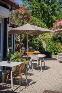a group of tables and chairs under an umbrella at Kyriad N&icirc;mes Ouest A9 in N&icirc;mes