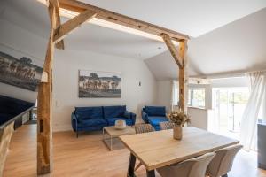 a living room with a table and a blue couch at Reethus 22 Loft 6 in Timmendorfer Strand