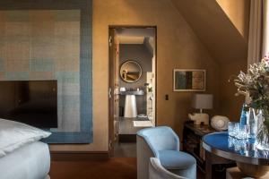 a bedroom with a bed and a table and a mirror at Cour des Vosges - Evok Collection in Paris