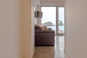 a living room with a couch and a view of the ocean at La Finestra di Verga in Aci Castello