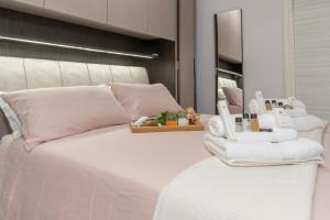 a bedroom with a white bed with towels on it at La Finestra di Verga in Aci Castello