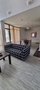 Una sala de estar con un sofá en el medio de una habitación. en Sunny house, en Pismenovo