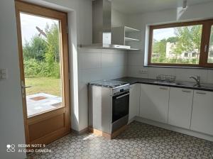 a kitchen with a stove and a sink and a window at Chez Hubert in Chimay